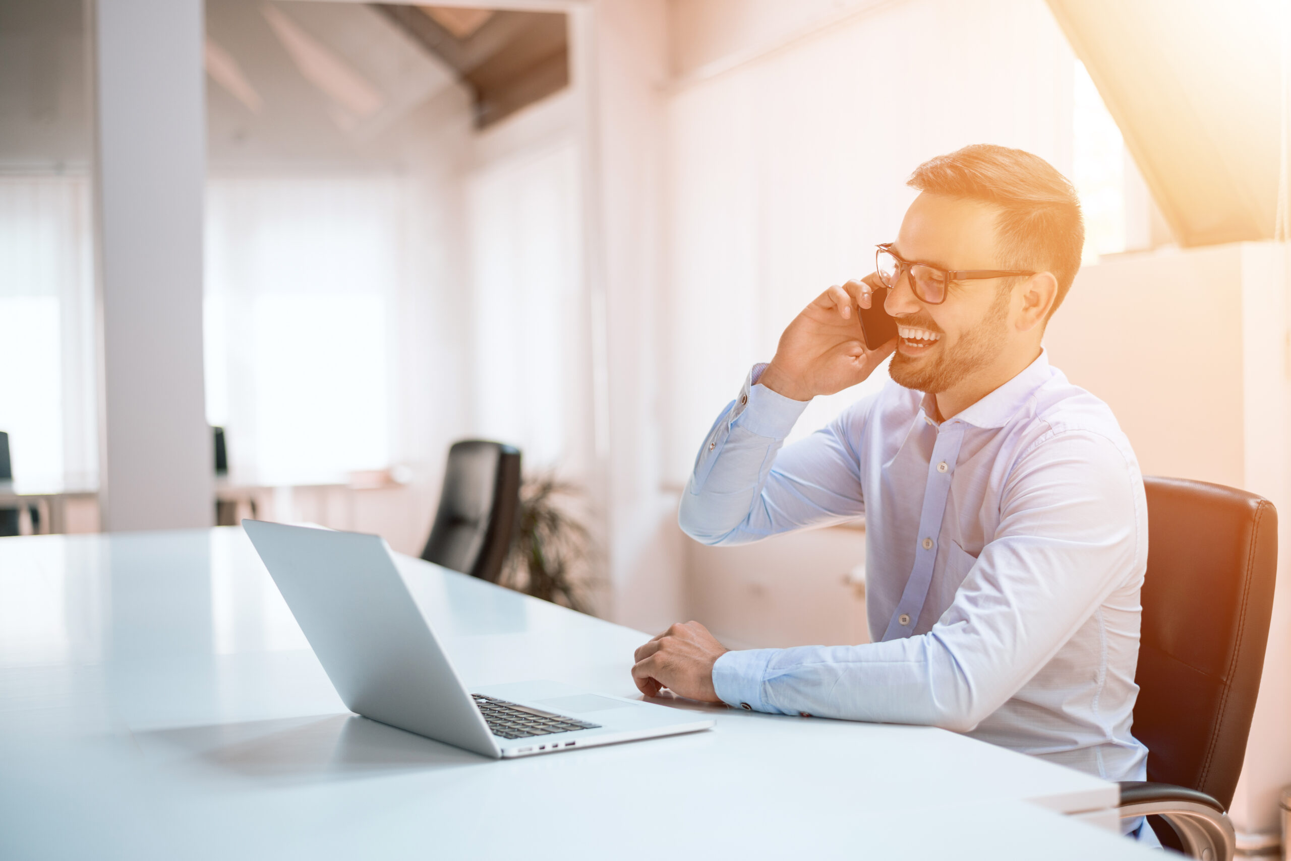 Confident young man talking on the phone in the office